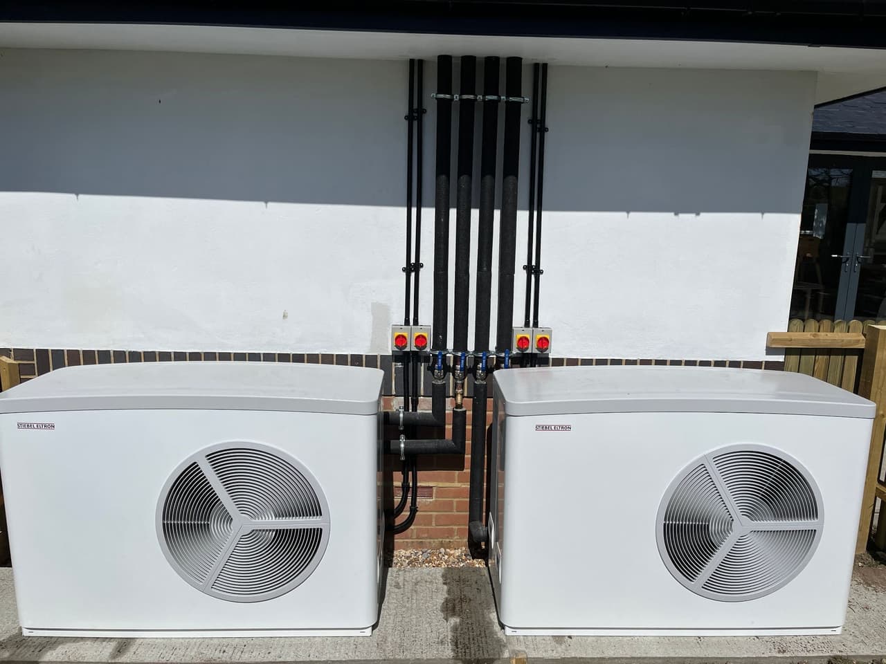 Two air source heat pumps installed by Solwat outside a home