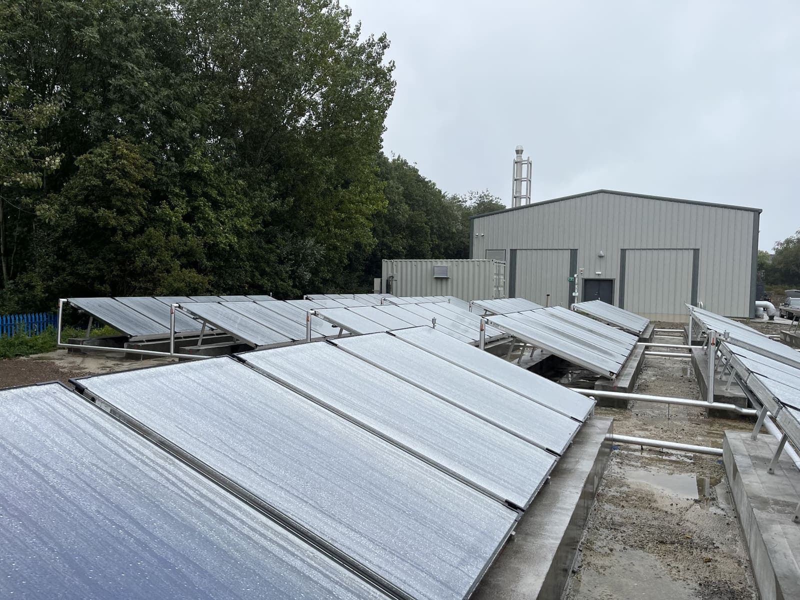 Solar thermal collectors on frames beside a commercial building